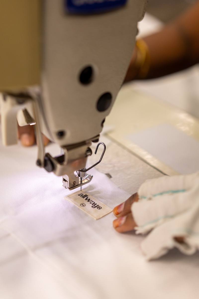 An allways label being stitched at a sewing machine