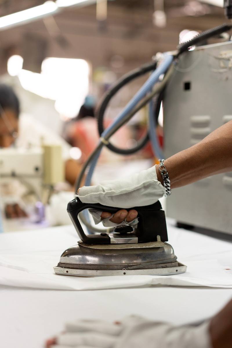 A white shirt being pressed with an iron at the factory